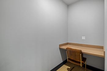 a desk and a chair in a room with white walls